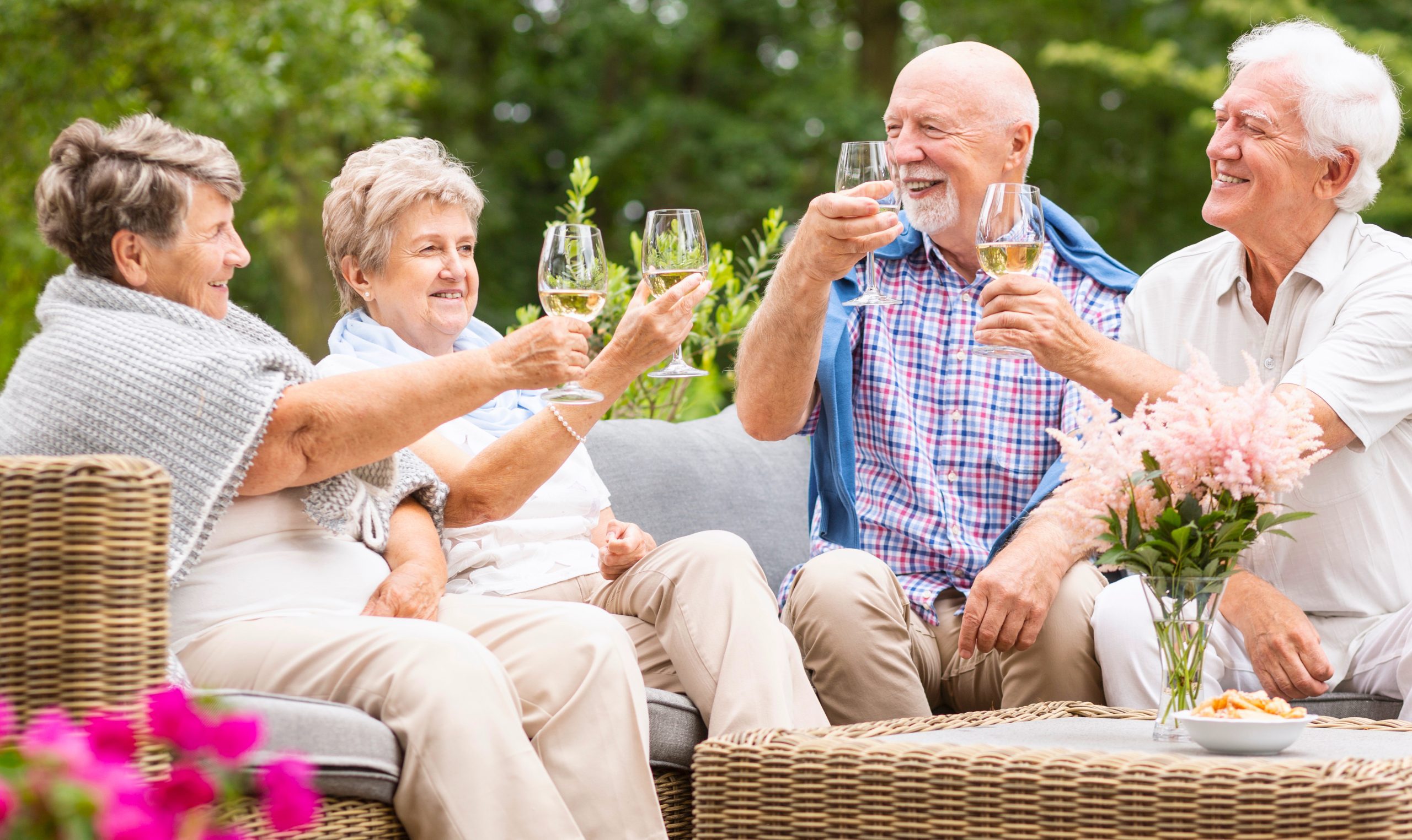 Four senior friends drinking wine outdoors