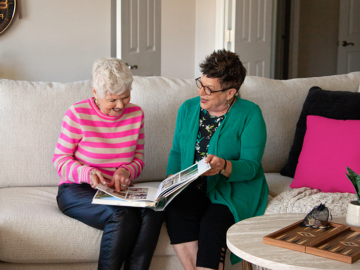 Two senior ladies looking through a photo album