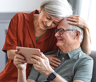 Senior lady and man looking at a tablet